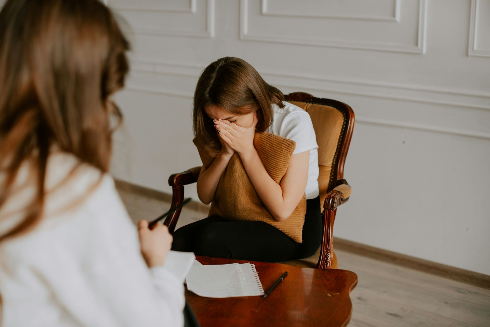 A young person sitting with a therapist during a session
