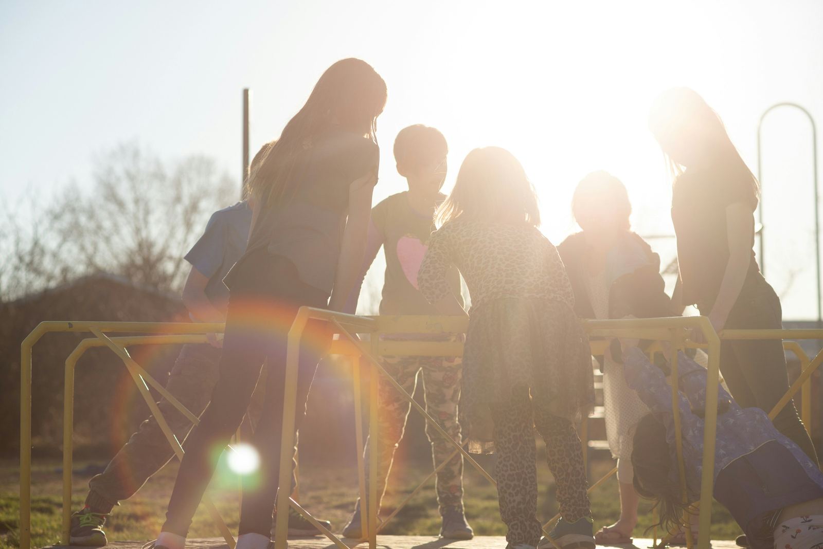 Children playing together on a playground in bright sunlight