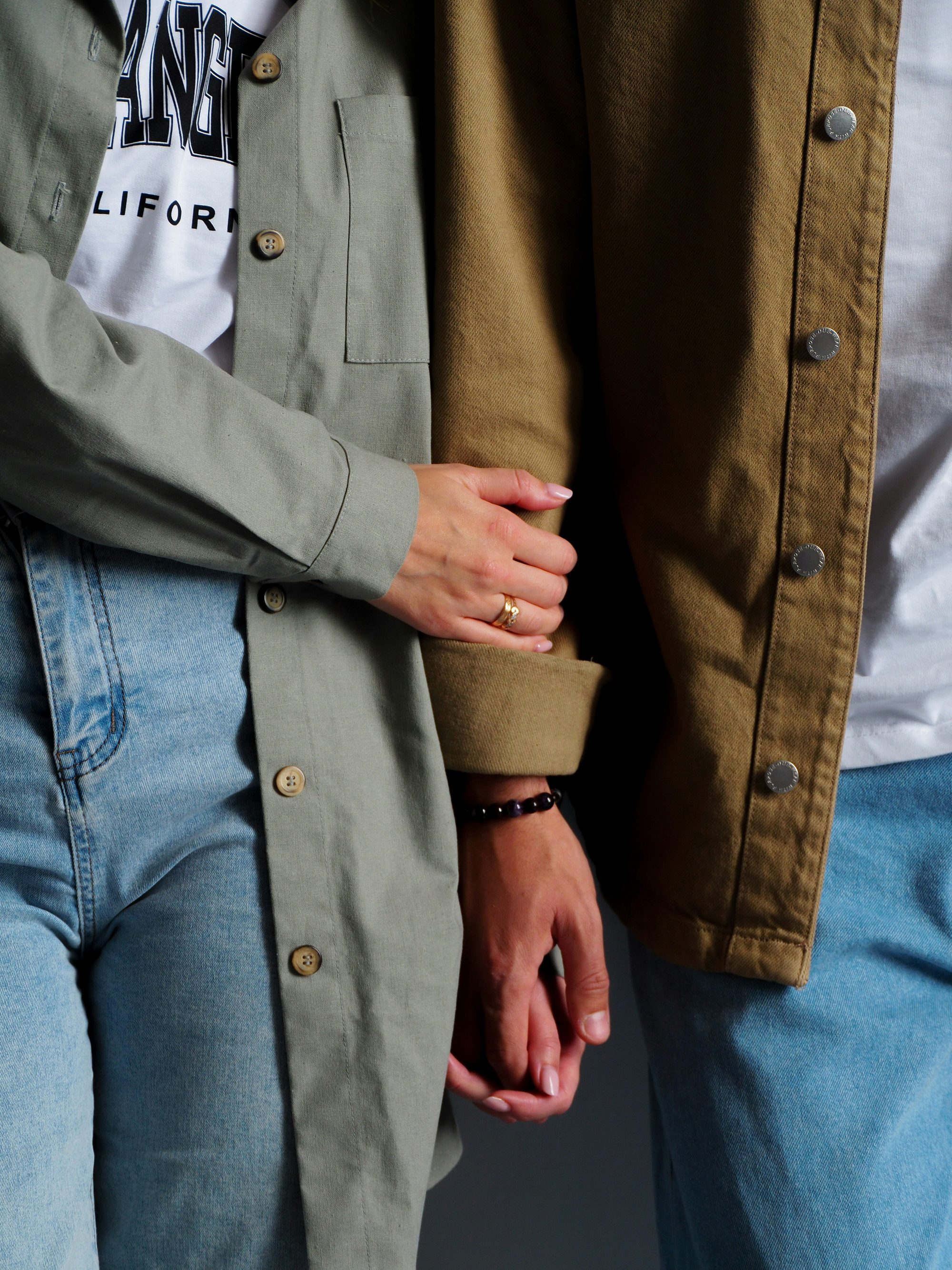 Two teenagers holding hands, photographed close and cropped