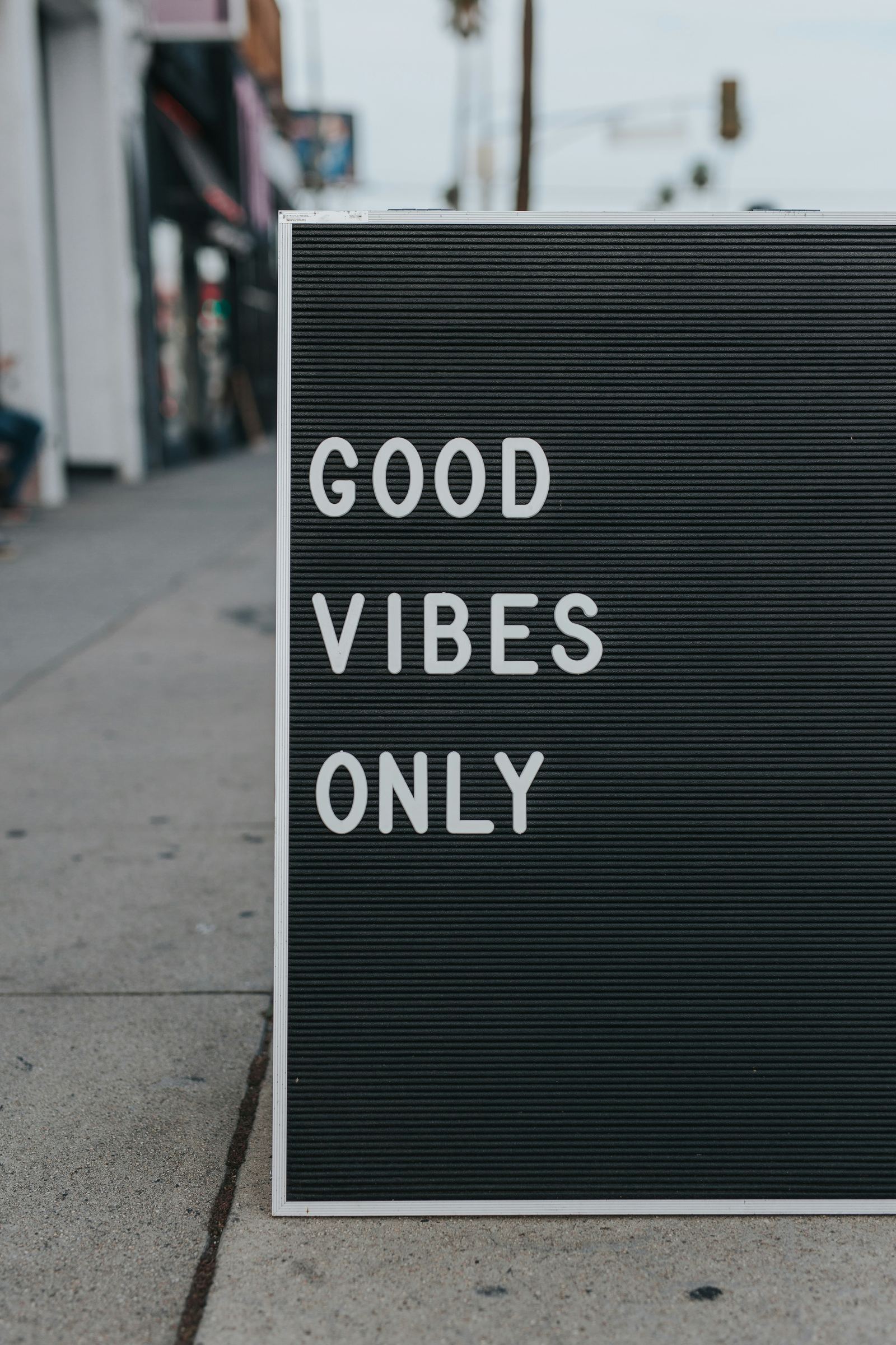 A letterboard sign on a street reading good vibes only