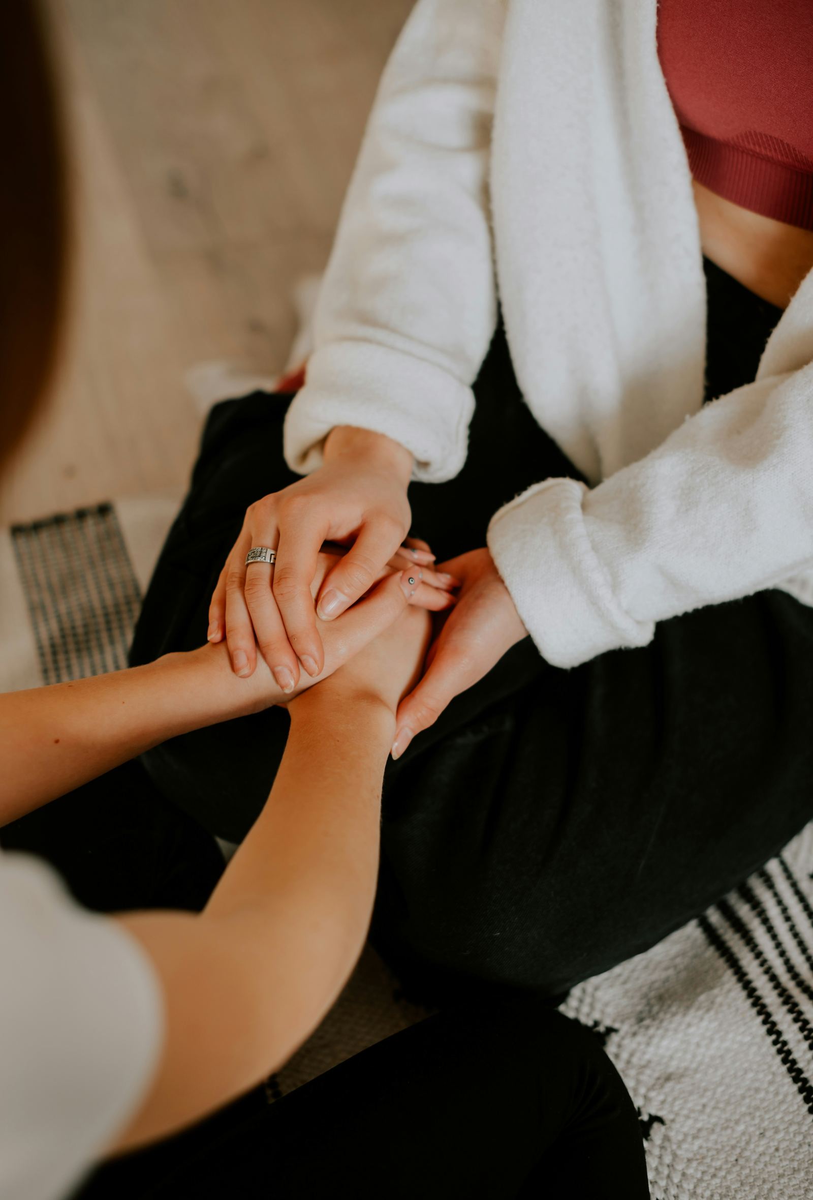 Two people holding hands during a supportive conversation