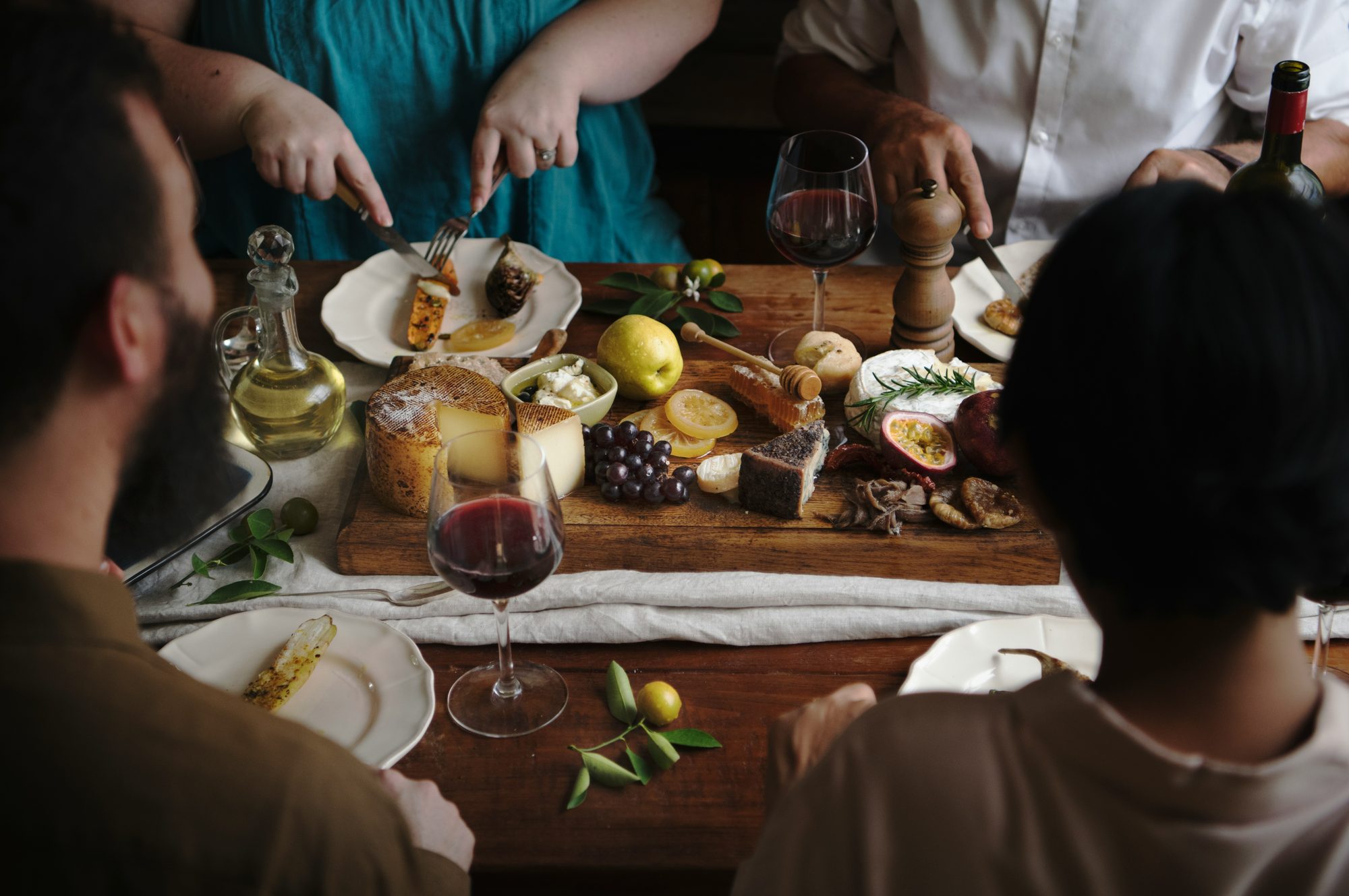 A family gathered around a table full of food, talking over a shared meal
