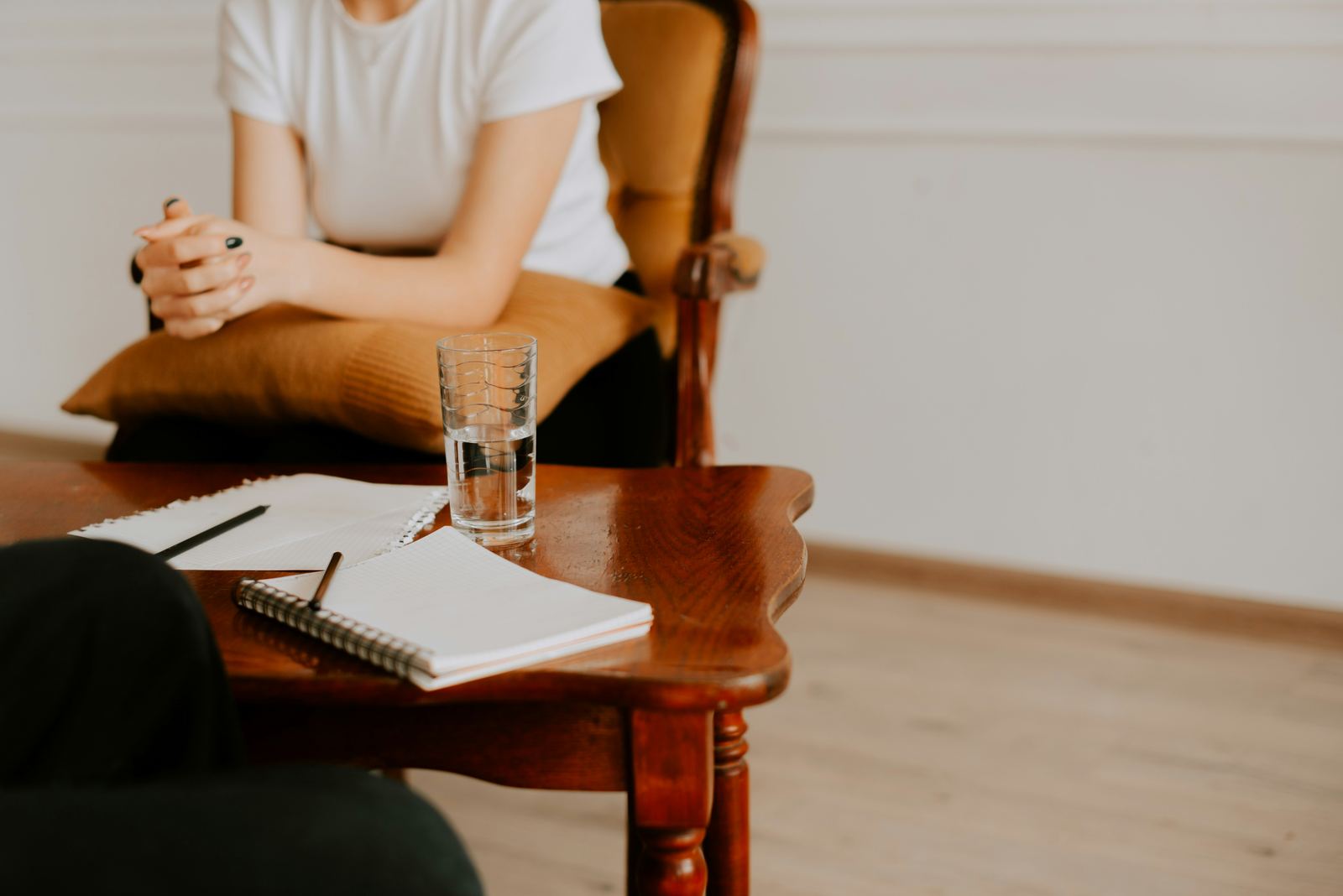 A therapist sitting with a notebook during a consultation