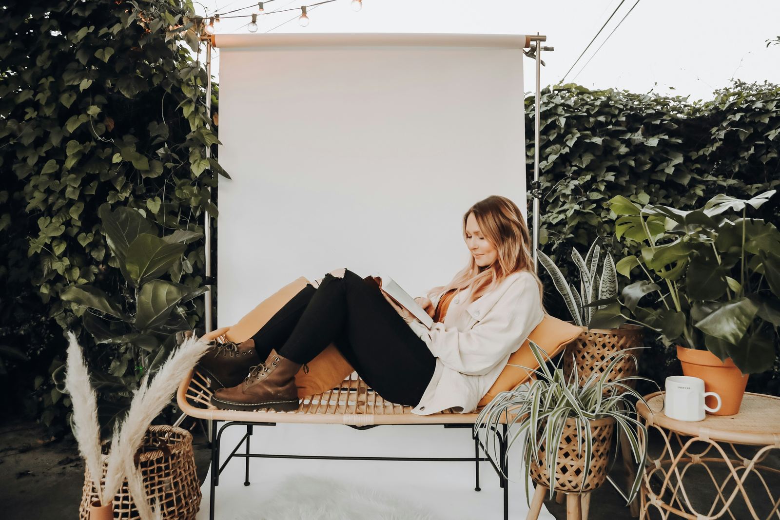 A person sitting quietly reading surrounded by plants