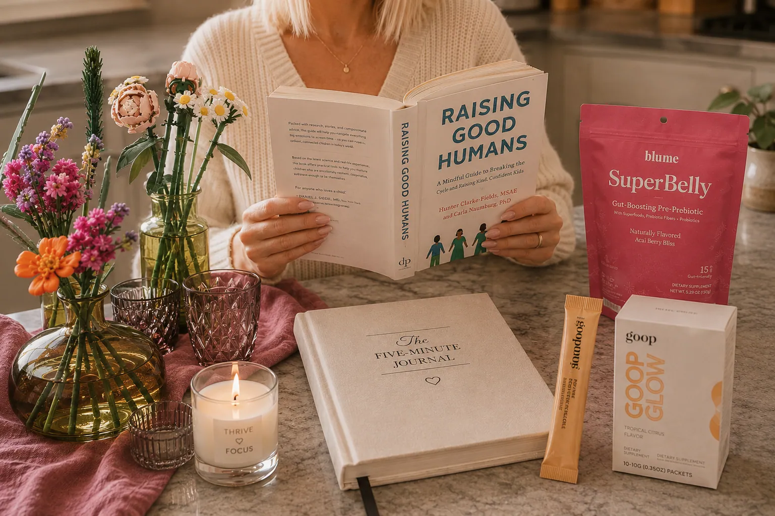 Sian reading Raising Good Humans at a kitchen counter with a Thrive Focus candle, The Five-Minute Journal, and therapist-recommended wellness products