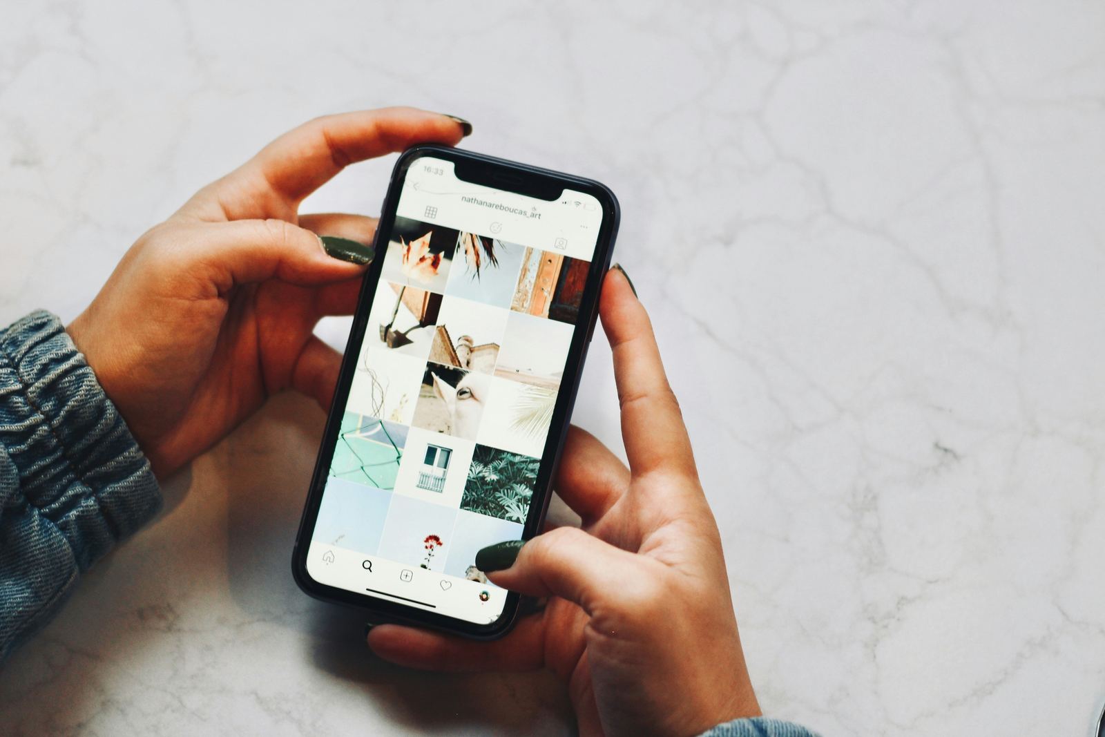 Hands scrolling through a social media feed on a phone