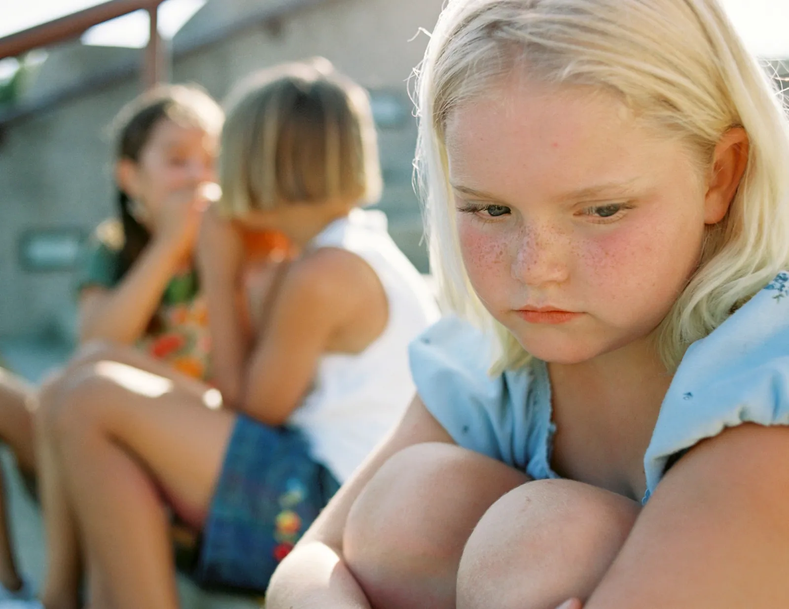 A school-age child sitting quietly after a difficult day while a parent waits nearby without pressing for words