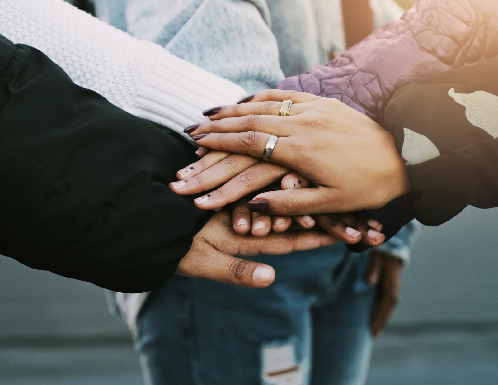 A family stacking their hands together as a symbol of sharing the work of family life