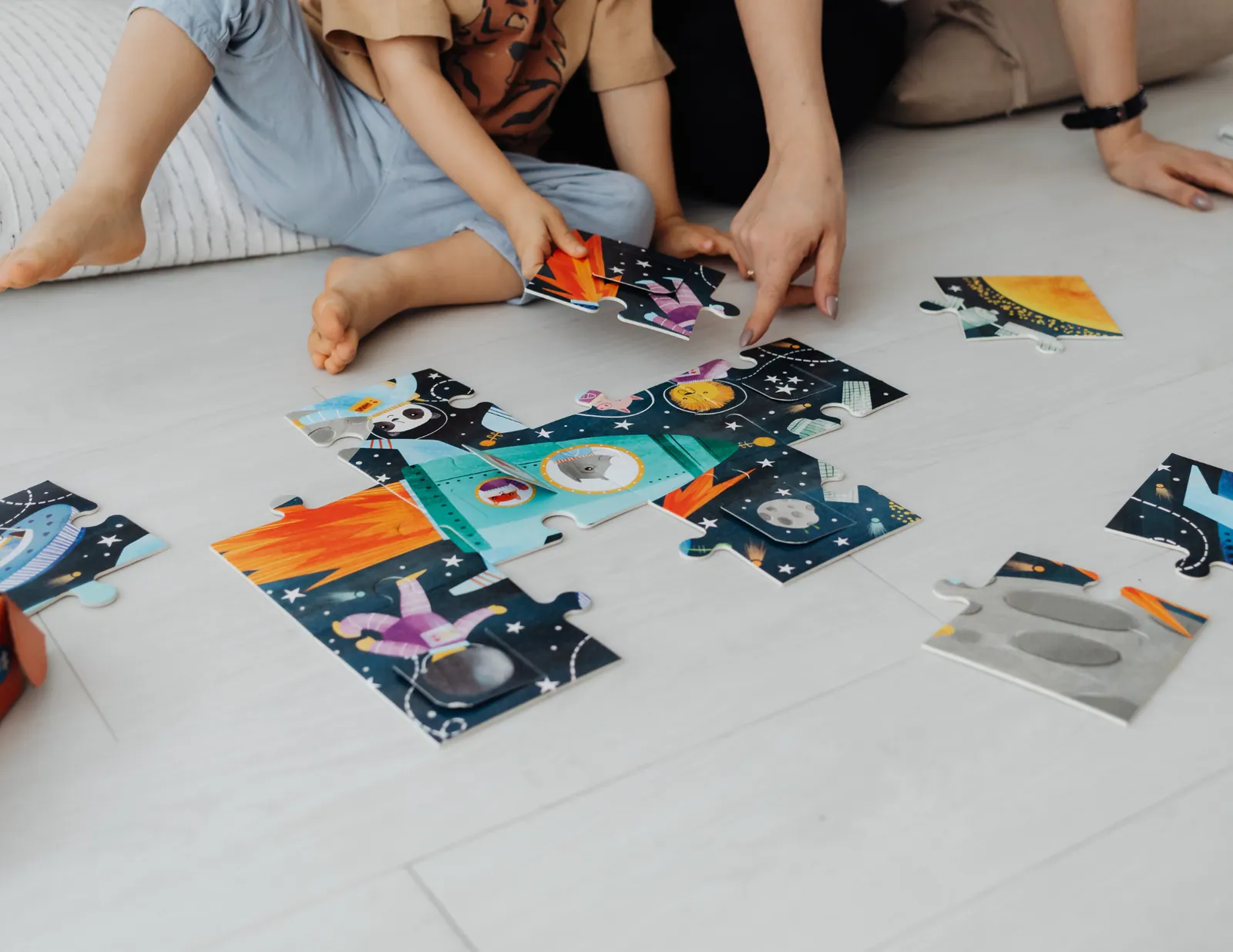 A child leading a relaxed collage activity while family members sit alongside and follow their ideas