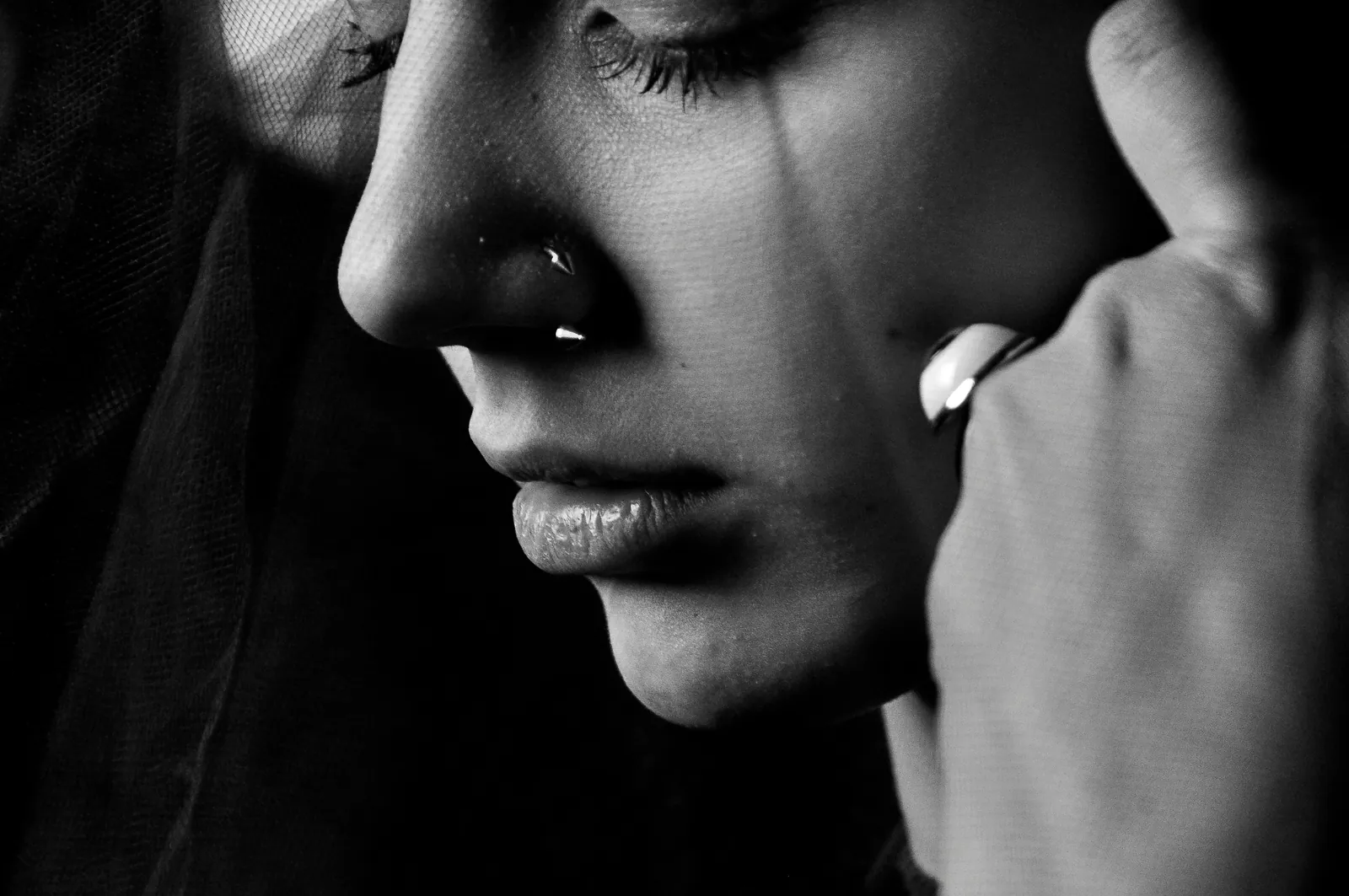 A close black and white portrait of a teenager with eyes closed, breathing hard