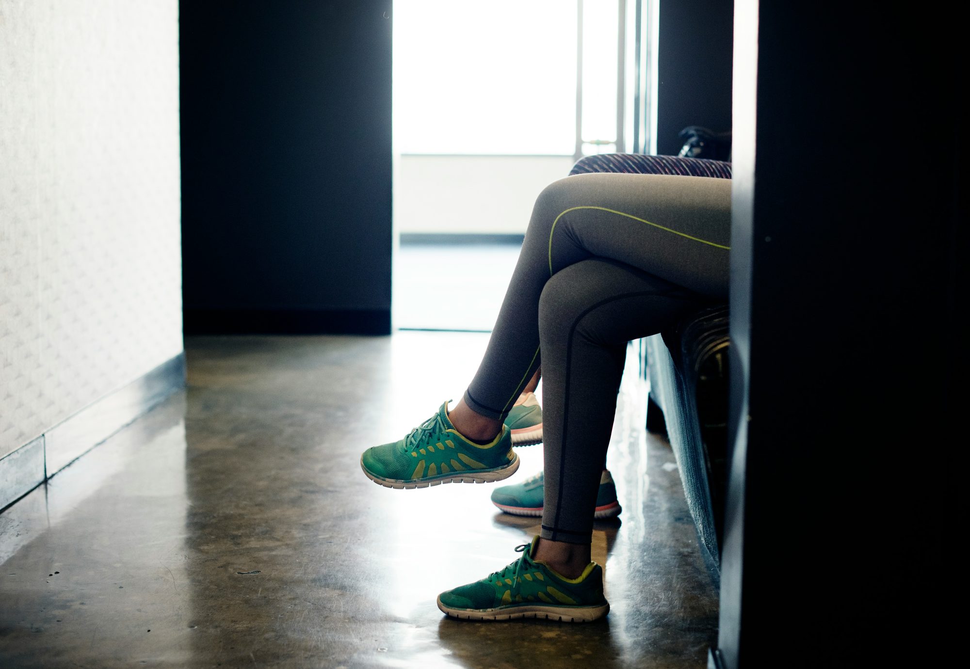 A teenager sitting quietly out of sight behind a doorway