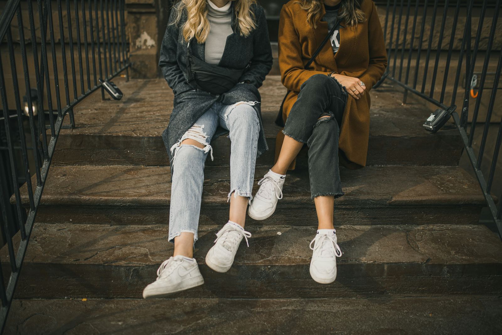 Two teenagers sitting apart on a set of steps