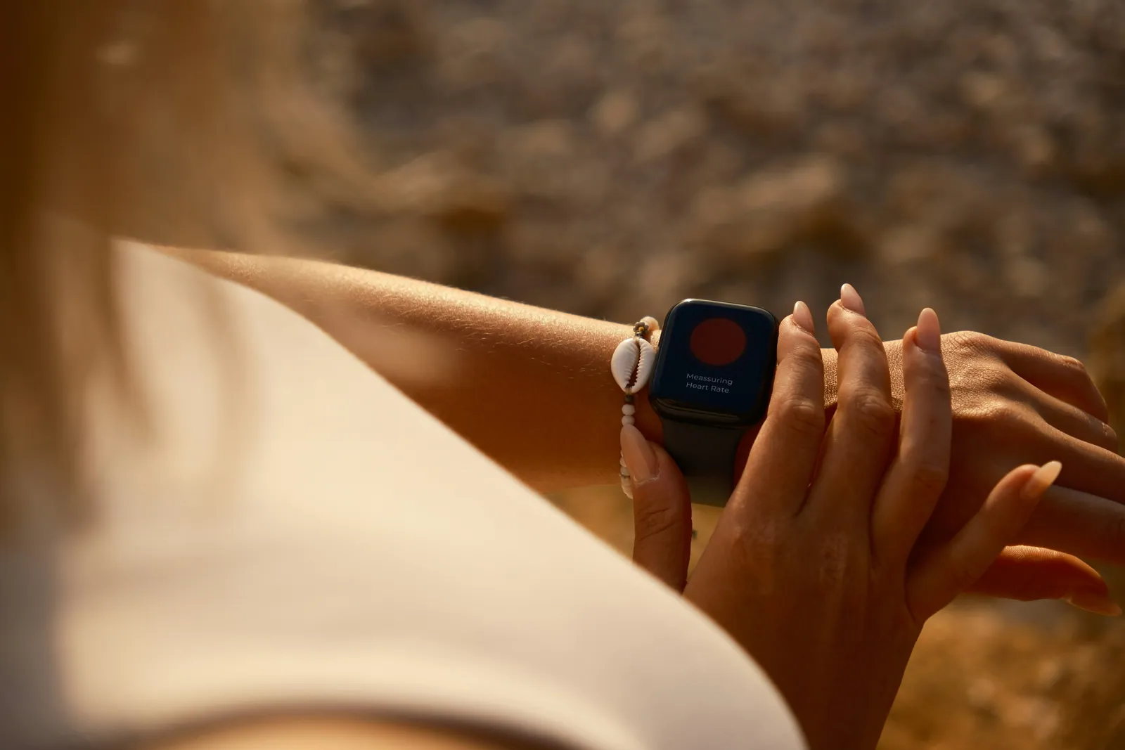 A young athlete checking a fitness watch after training, warm evening light
