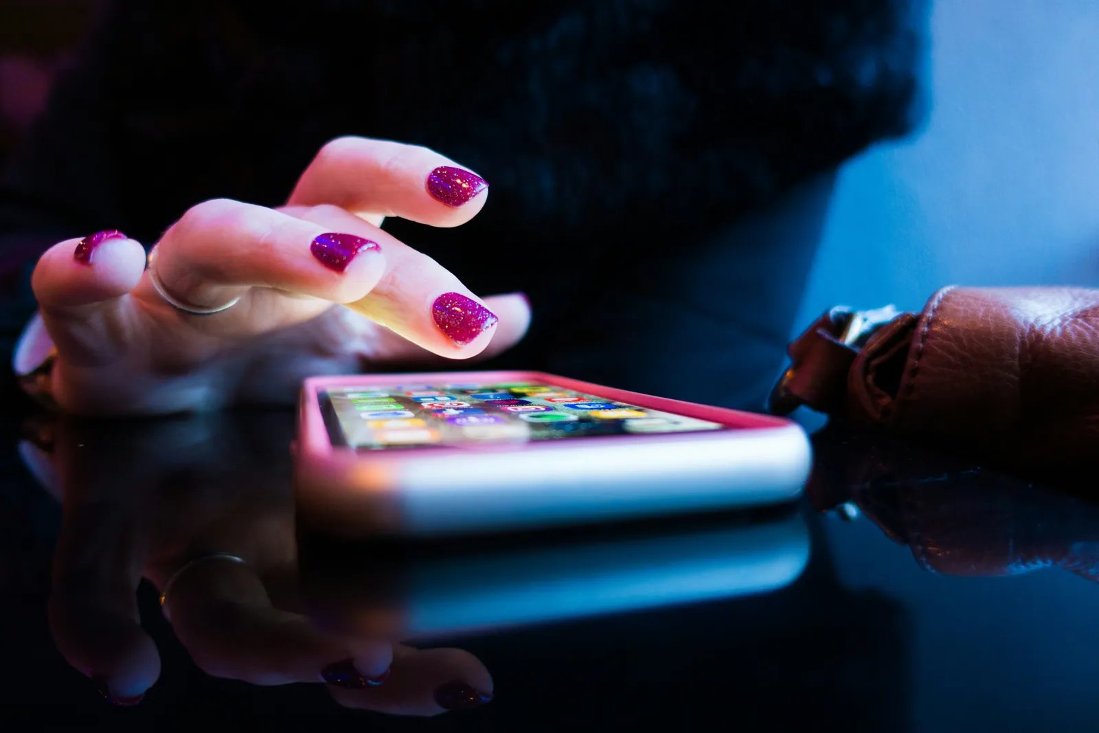 A tablet glowing blue in a darkened bedroom, held by a child's hands late at night