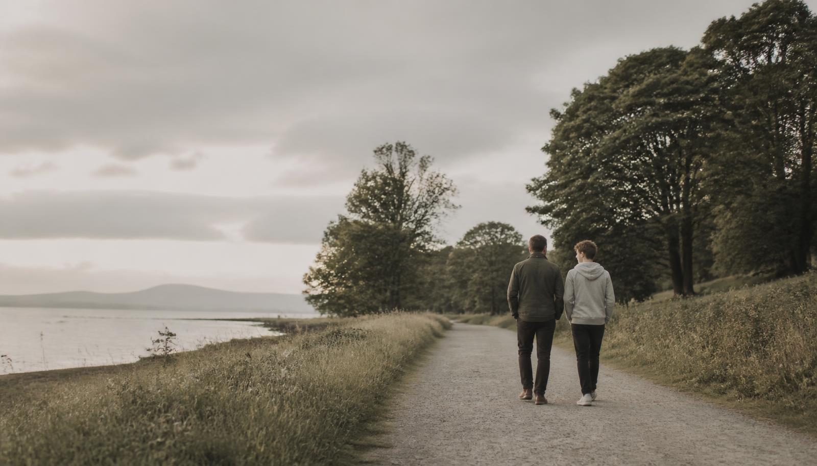 A father and his teenage son walking a quiet path together