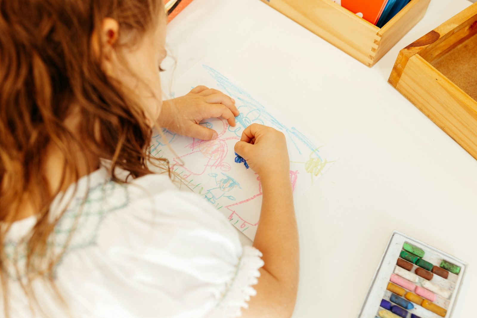 A child working at a kitchen table in afternoon light